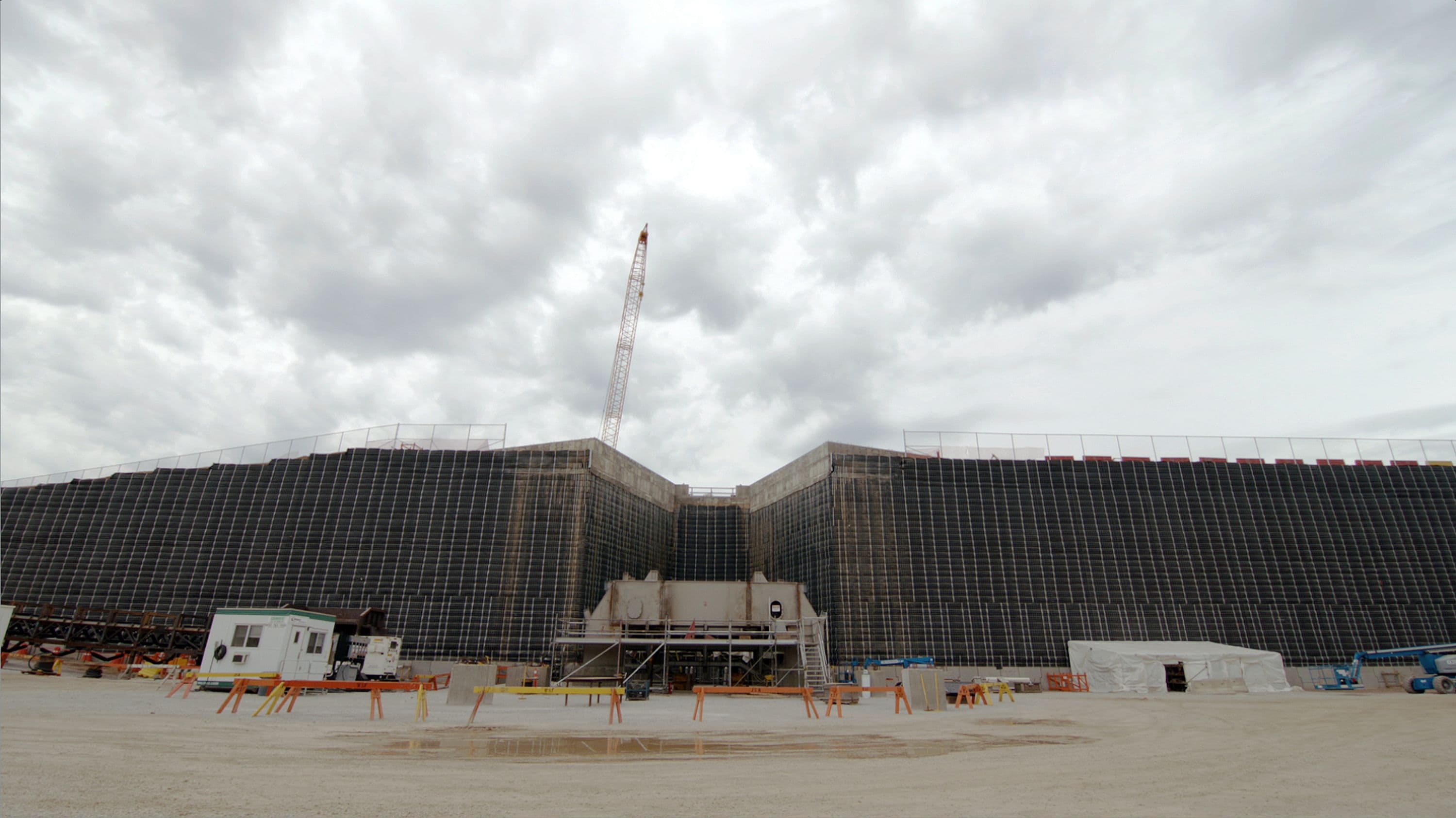Completed mechanically stabilized earth wall and start of crusher installation